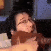 a man with glasses is playing a guitar in a video game .