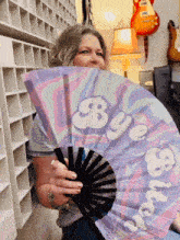 a woman holding a fan that says bye bitch on it