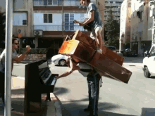 Man Play Piano With A Piano And Another Guy Playing Guitar On His Back GIF - Piano Guitar Balance GIFs