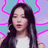 a girl with long black hair is wearing a pink headband and a microphone