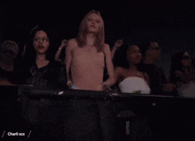 a group of people are making a heart shape with their hands at a concert