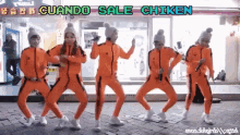 a group of people are dancing in front of a store that says cuando sale chiken