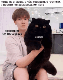 a man is holding a black cat in his arms with a caption in russian
