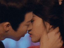 a man and a woman are kissing in front of a window .