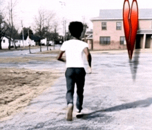 a boy is running towards a broken heart in the background
