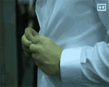 a man in a white shirt is getting ready to go out