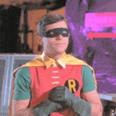 a man in a robin costume with the letter r on his shirt