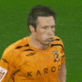 a man wearing a yellow shirt with karoo written on the front