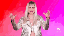 a woman in a silver jacket is dancing on a pink and red background
