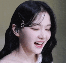 a close up of a woman 's face with a star in her hair clip