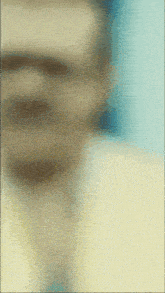a blurry picture of a man 's face with a yellow shirt and tie