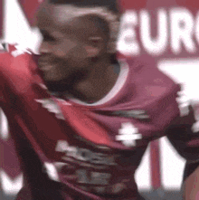 a close up of a soccer player in a red jersey