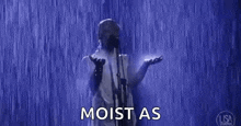 a man is singing into a microphone in the rain while standing in the rain .