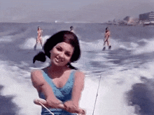 a woman in a blue bathing suit is riding a boat in the water .