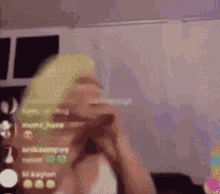a woman with blonde hair is talking on a cell phone in a living room .