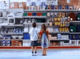 a boy and a girl are standing next to each other in a store looking at shelves .