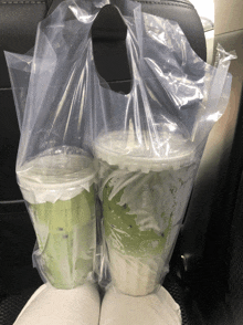 two cups in a plastic bag that says ' smoothie ' on the front