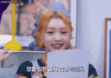 a woman is smiling and holding a piece of paper in front of her with the words honeycam.org below her