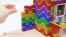 a rainbow colored building made of magnets with the words made in animatica on the bottom