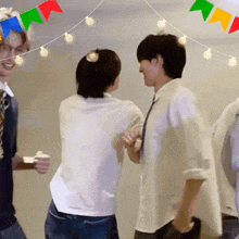 a group of people are dancing in a room with flags in the background .