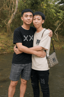 two young men hugging each other with one wearing a shirt that says xx on it