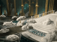 a woman in a white dress walks down a set of stairs
