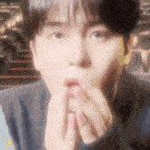 a close up of a person covering their mouth with their hand
