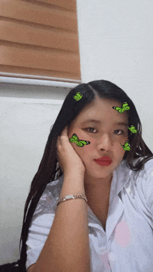 a girl with green butterflies on her face looks at the camera