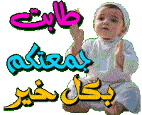 a baby is sitting in front of a sign in arabic