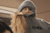 a woman wearing a michael kors hoodie is standing next to another woman