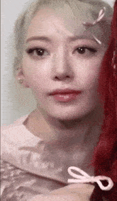 a close up of a woman 's face with a bow on her hair