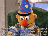 bert from sesame street wearing a party hat is sitting in a chair