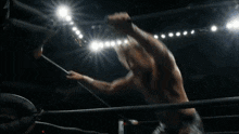 a wrestler is doing a handstand in a wrestling ring in front of a crowd .