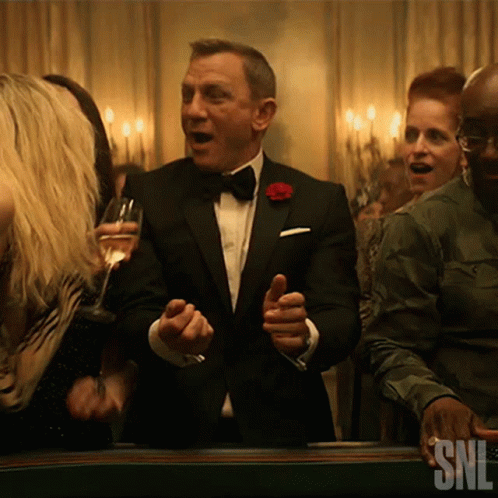 a man in a tuxedo is dancing in front of a snl ad