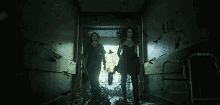 two women walking down a dark hallway with a walker in the background