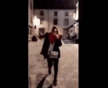 a woman wearing sunglasses and a red jacket is making a face .