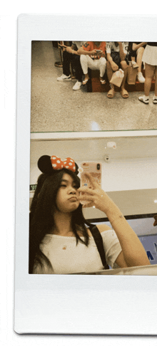 a woman wearing a minnie mouse headband takes a selfie