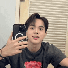 a young man is taking a selfie with his cell phone