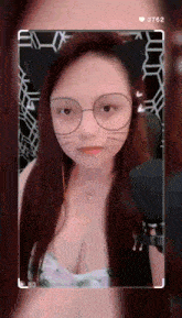 a woman wearing cat ears and glasses is taking a selfie .