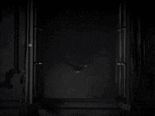 a black and white photo of a person looking out a window