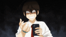 a man in a white shirt and red tie is smiling while holding a cellphone