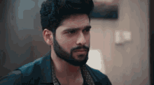 a man with a beard wearing a black shirt and polka dot vest