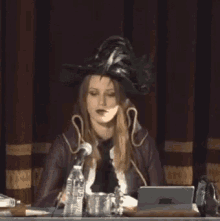 a woman in a pirate hat is speaking into a microphone while sitting at a desk