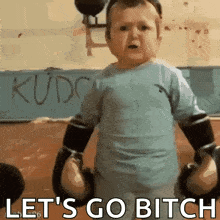 a little boy is wearing boxing gloves and says let 's go bitch