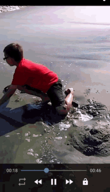a video of a boy playing in the water is being played on a cell phone