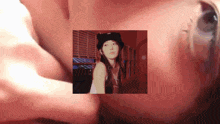 a picture of a woman wearing a black hat and a white tank top