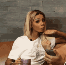 a woman sitting on a couch holding a cup that says ' rumina ' on it