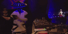 a man wearing a hat and headphones playing a dj set