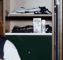 a woman looking at a shelf with a box that says ' off ' on it