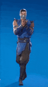 a man in a blue suit and mask is standing on a blue background .